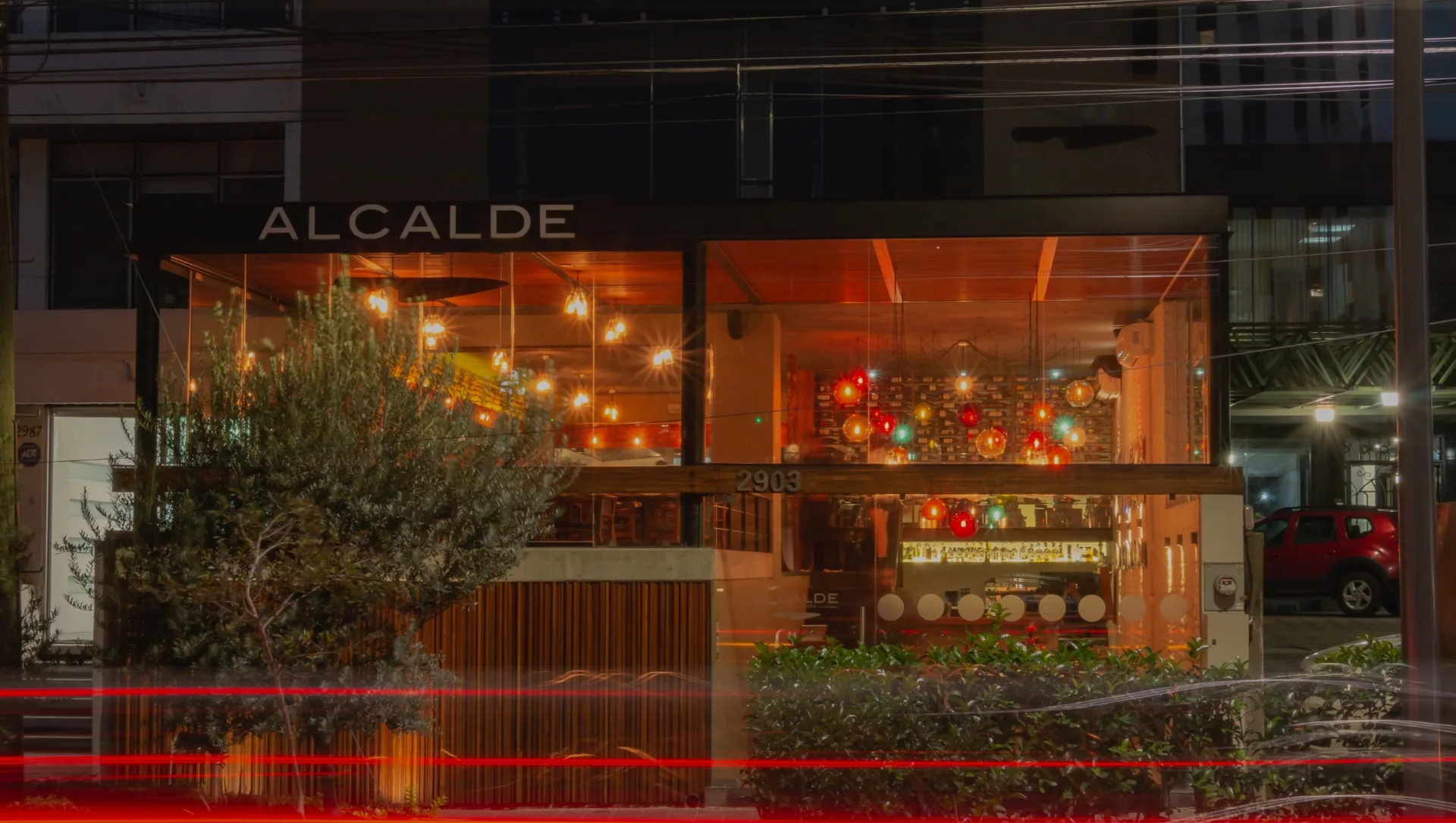Fachada de Alcalde en avenida México, iluminada al anochecer.