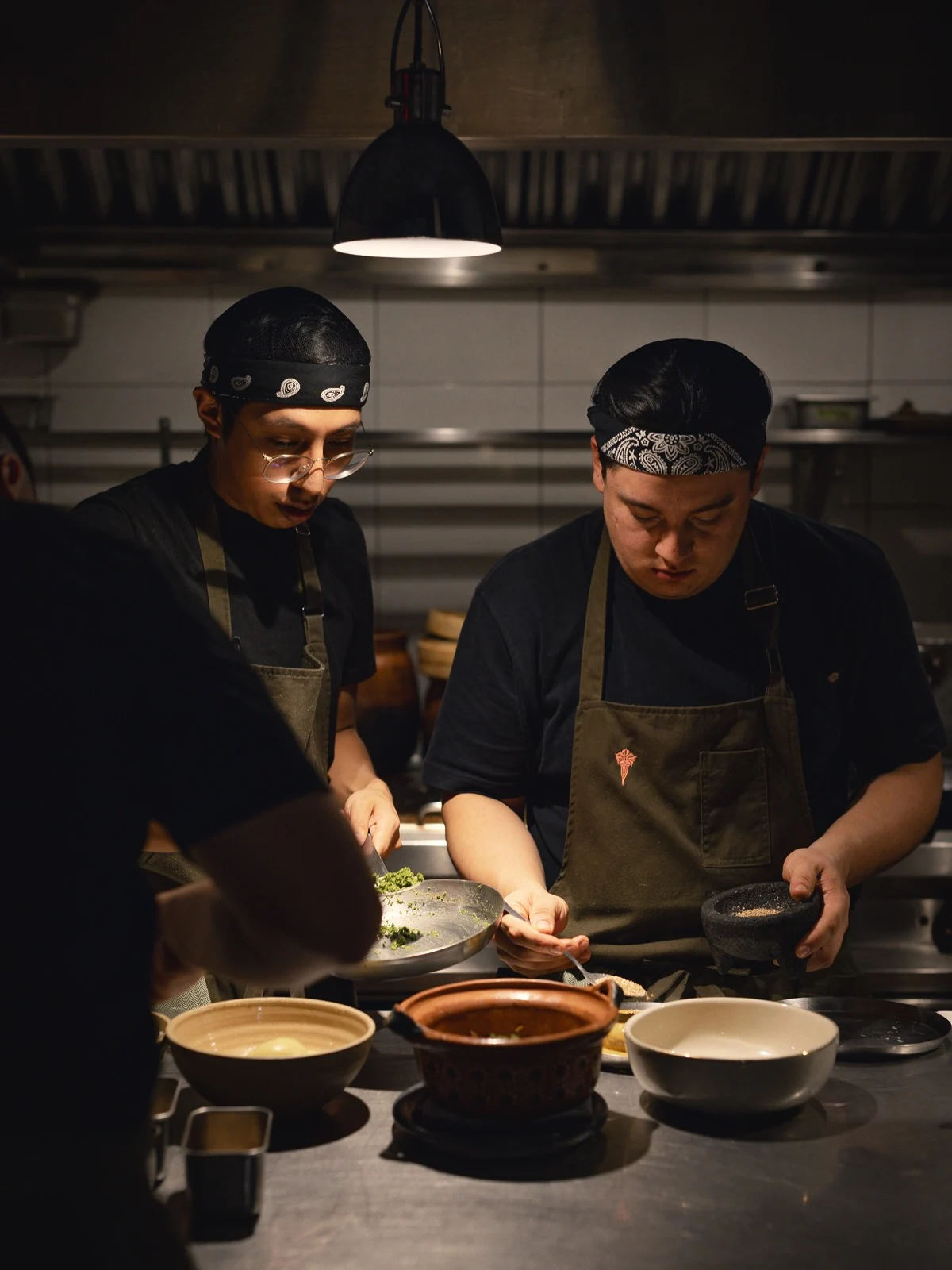 Dos integrantes del equipo de Alcalde emplatan durante el servicio en la cocina.