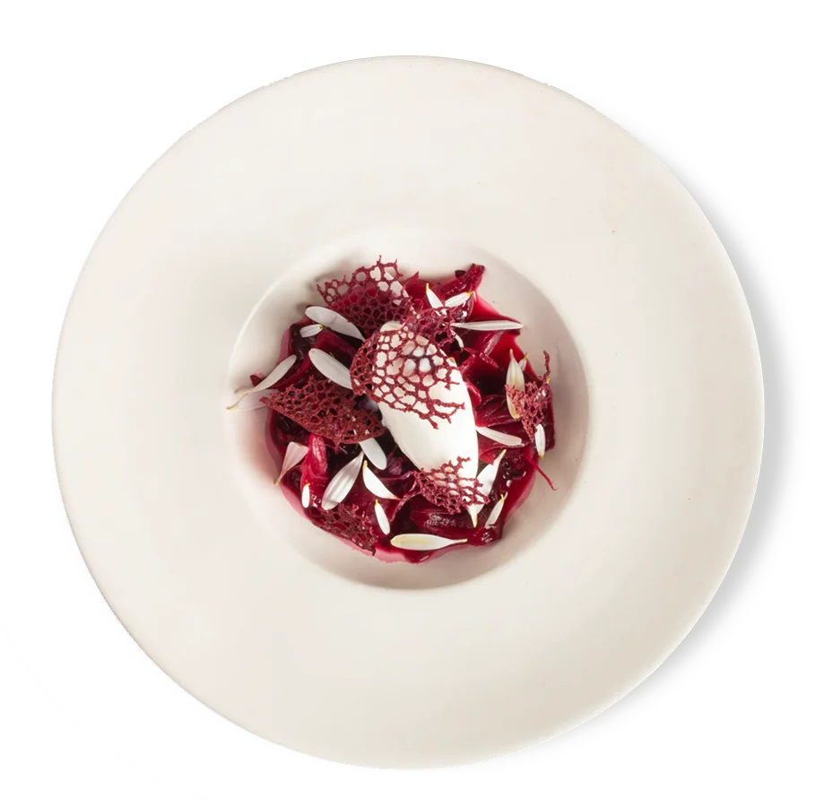 Composición de Alcalde en tonos granate y blanco, servida en un plato blanco visto desde arriba.