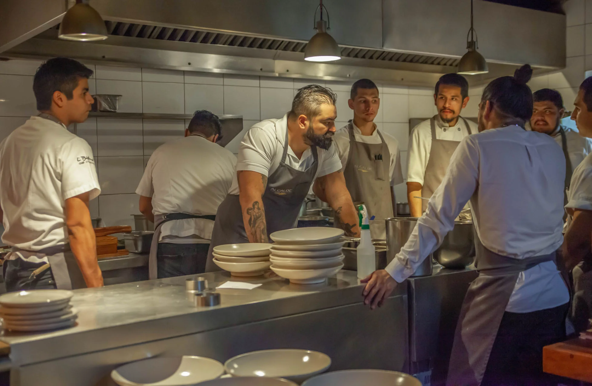 Paco Ruano conversa con su equipo alrededor de la mesa de trabajo en la cocina de Alcalde.